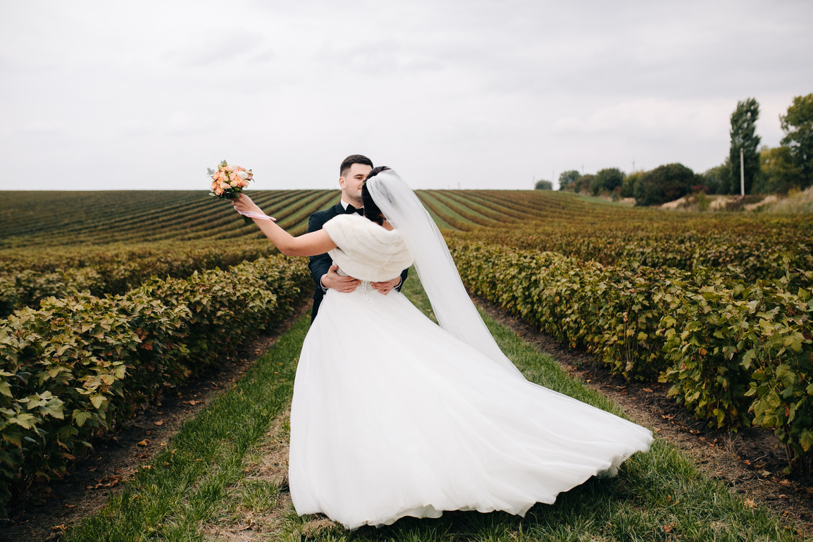 Happy Wedding Couple Hugging and Smiling Each Other on the Background Gorgeous Plants